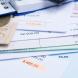 Mortgage and utility bills, foreign coins and banknote, calculator, different amounts