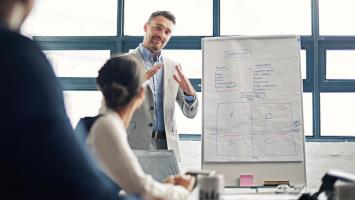 Formation professionnelle avec présentation sur tableau blanc.