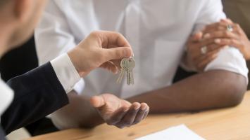 propriétaires de maison reçoivent les clés de l'agent immobilier