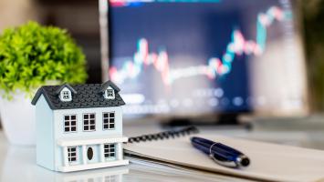 Modèle maison, stylo et bloc-notes sur la table, marché immobilier, négociation d'investissement