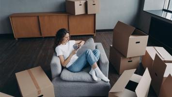 femme dans un fauteuil entouré de cartons