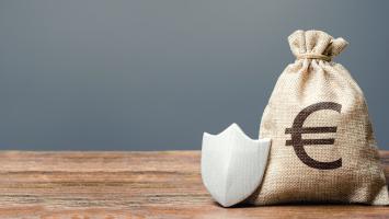 Un sac en toile de jute contenant des euros et un bouclier