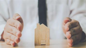 maisonette en bois entre les mains d'un homme qui la protège