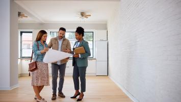 Un couple qui visite un appartement avec une femme agent immobilier