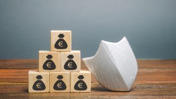 Un bouclier et des cubes de bois représentant des sacs d'argent