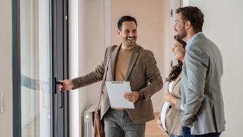 Un agent immobilier qui fait visiter un bien  un couple