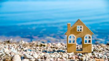Une maison miniature posée sur une plage de galets