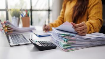 Une professionnelle de l'immobilier qui consulte des documents à son bureau