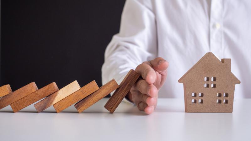 Main d’un homme qui protège une maison