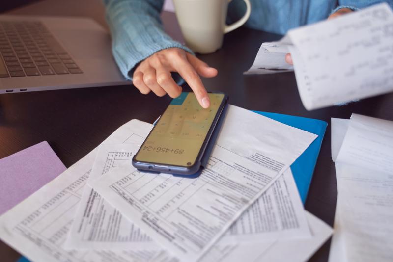 Gros plan sur une femme comptant les factures sur une calculatrice