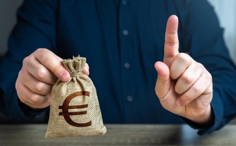 Un homme met en garde avec son doigt en offrant un sac à l'euro.