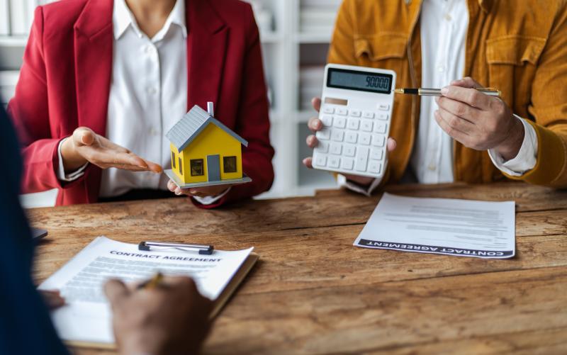 Homme d'affaires, agents immobiliers discutent des prix de vente de maison
