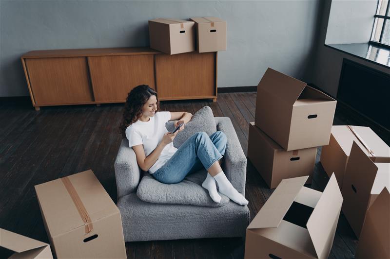 femme dans un fauteuil entouré de cartons