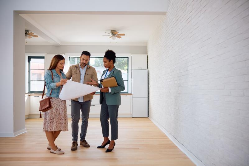 Un couple qui visite un appartement avec une femme agent immobilier