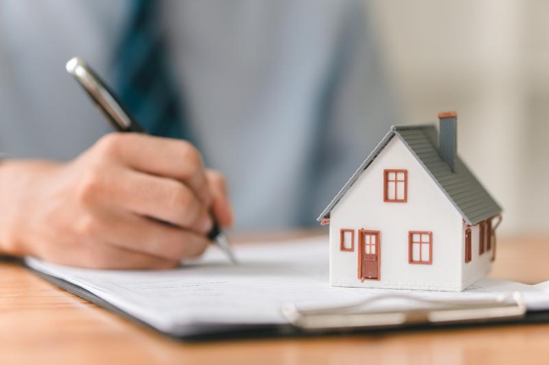 Modèle maison, stylo et bloc-notes sur la table, marché immobilier, négociation d'investissement