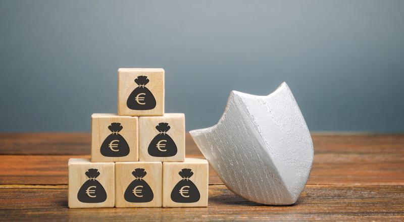 Un bouclier et des cubes de bois représentant des sacs d'argent