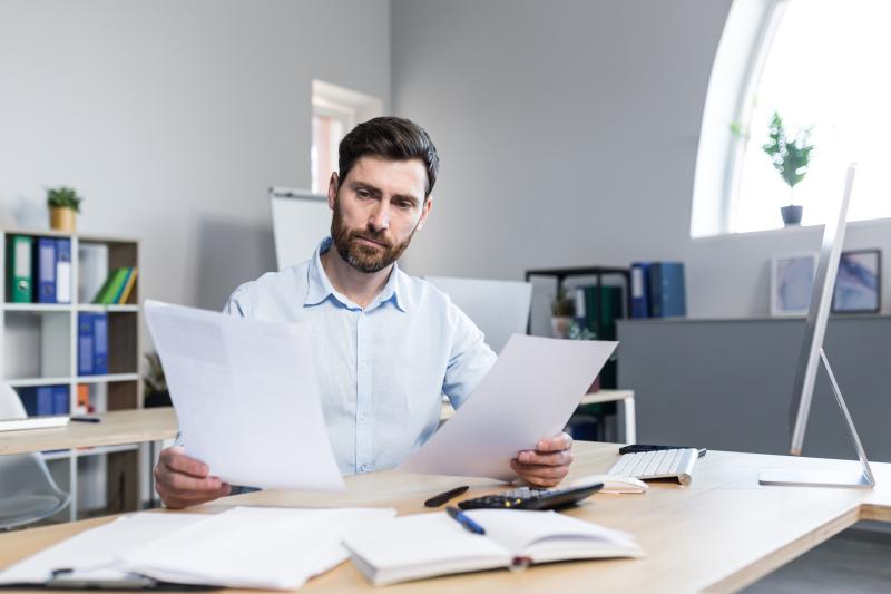 Un professionnel de l'immobilier entouré de documents 