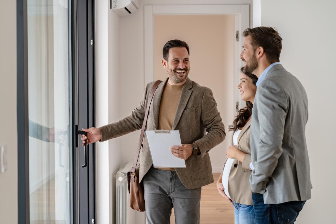 Un agent immobilier qui fait visiter un bien  un couple