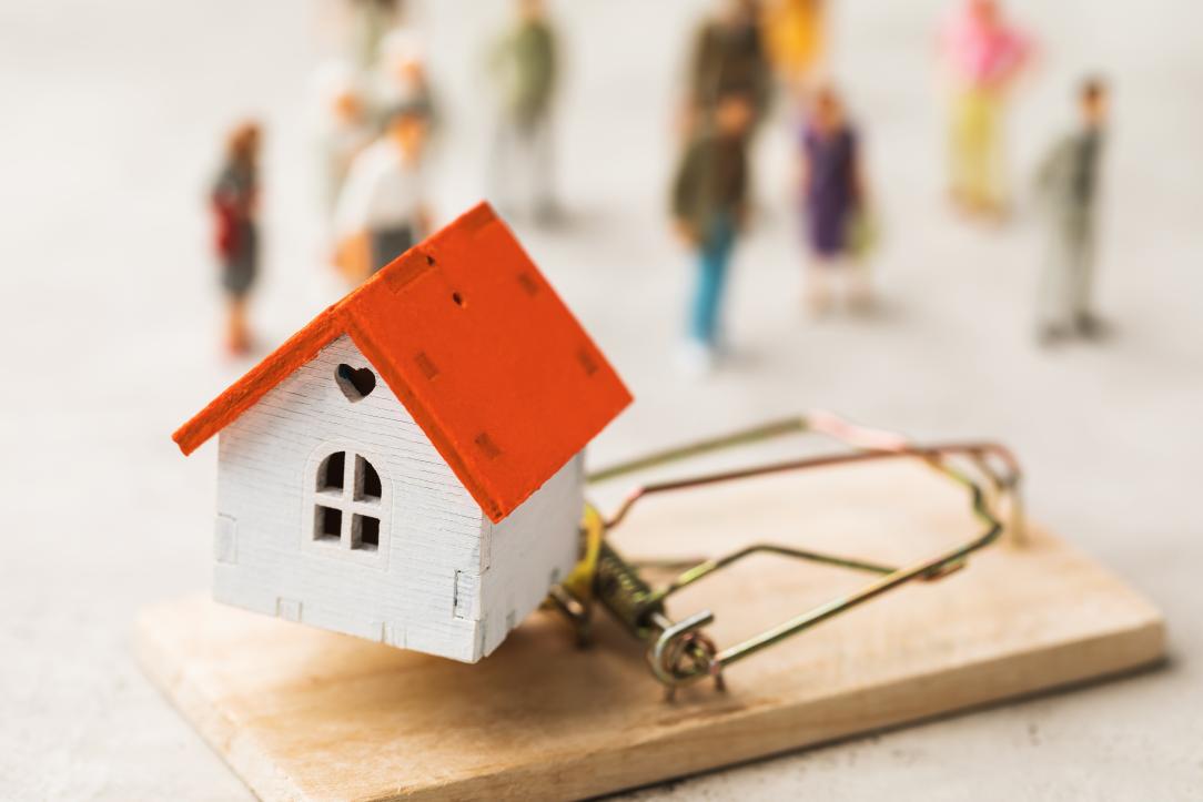 Une maison miniature posée sur un piège à souris