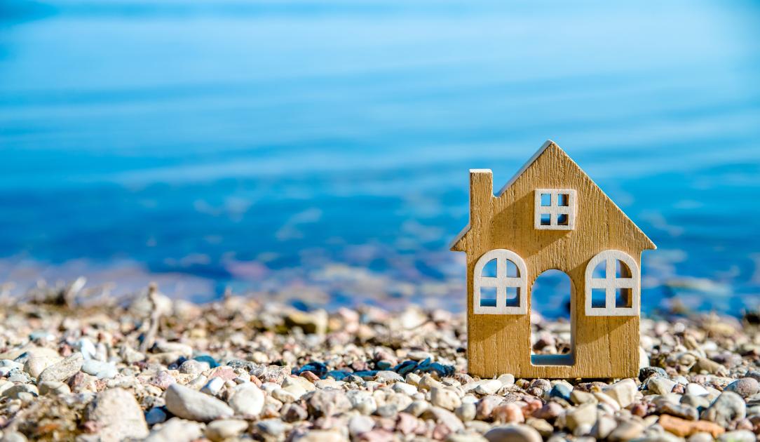 Une maison miniature posée sur une plage de galets